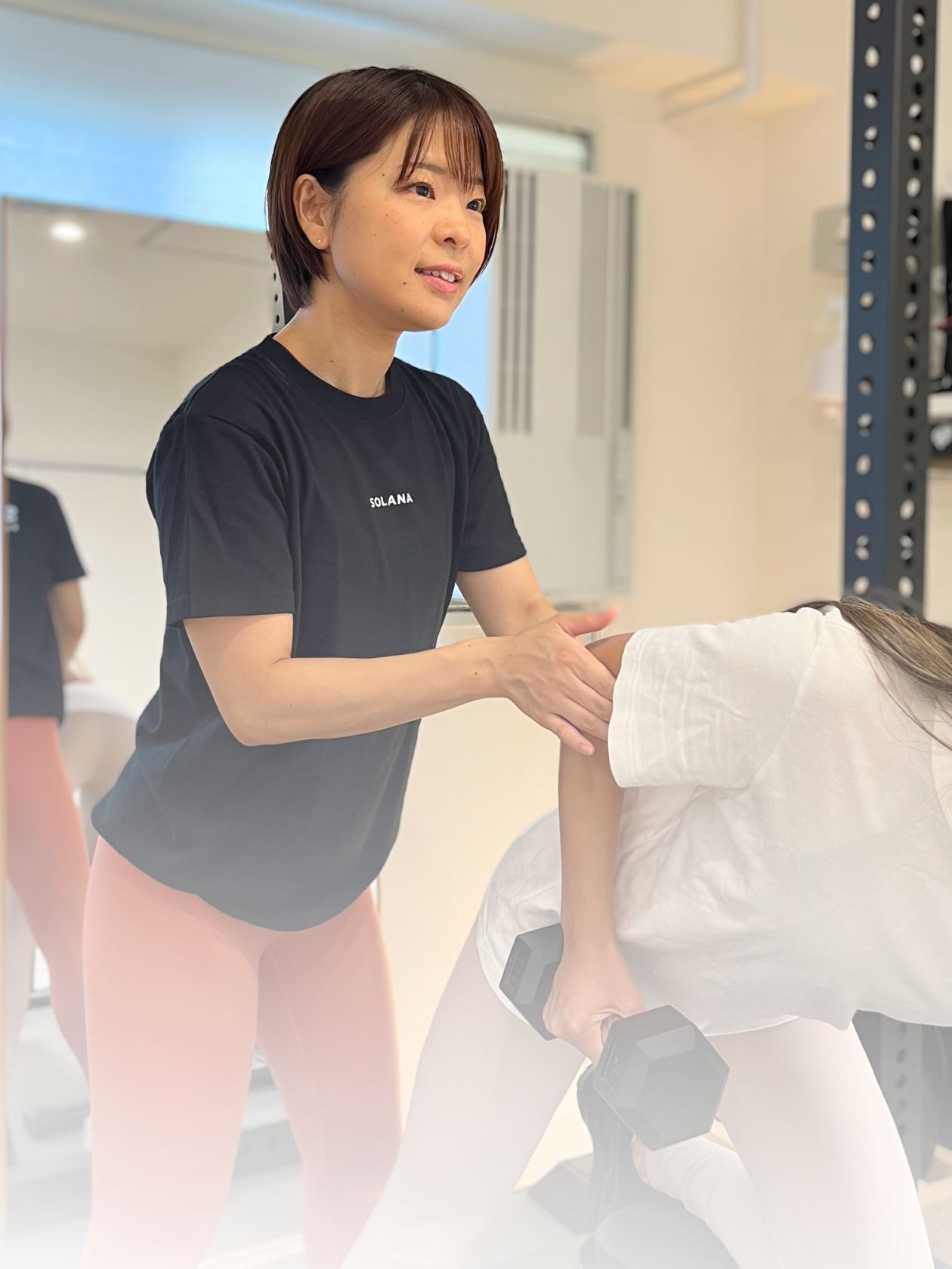 トレーニング指導している女性のパーソナルトレーナー